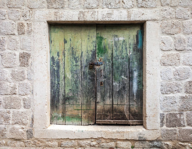 istock Locked old green wooden gate in stone wall 478025209