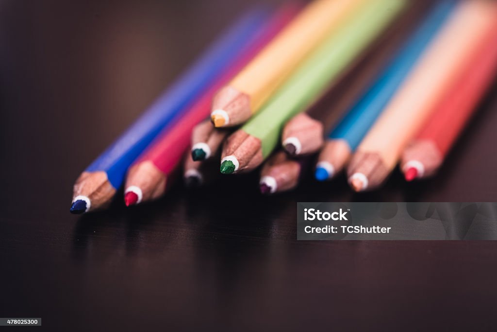 Color Pencils Cluster of Color Pencils stacked and grouped together on a clean wooden reflective table 2015 Stock Photo