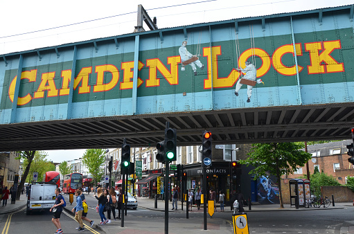 London, UK - May 27, 2015: view of Camden Lock sign in London, UK, with pedestrians and visitors. The sign marks the entrance to the Camden markets known for their vintage and alternative shopping.