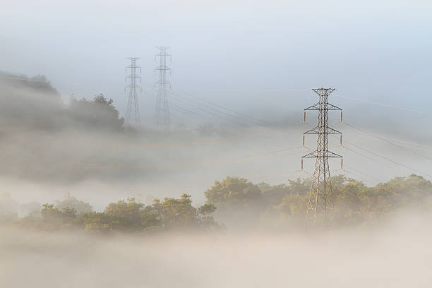 istock Electrical power lines and pylons emerging from the mist 478033821