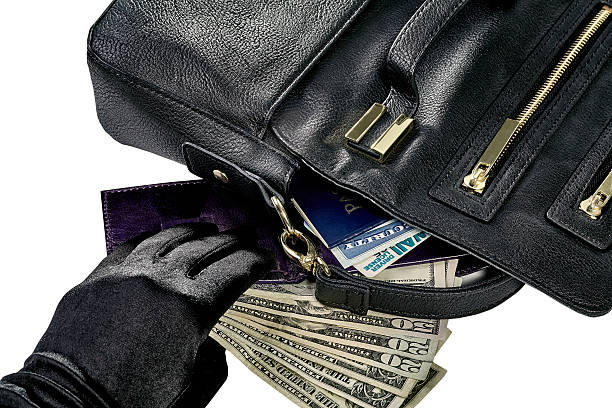 Identity Theft Women's purse with contents spilled including money, wallet, passport, social security card and driver's license and a hand reaching to steal the money social security social security card identity us currency stock pictures, royalty-free photos & images