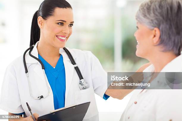 Female Doctor Comforting Middle Aged Patient Stock Photo - Download Image Now - Adult, Adults Only, Beautiful People