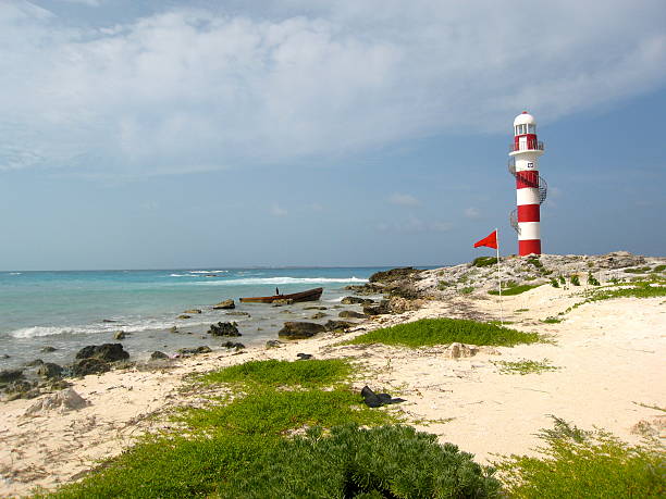 Single Lighthouse Guides Abandoned Boat in Cancun stock photo