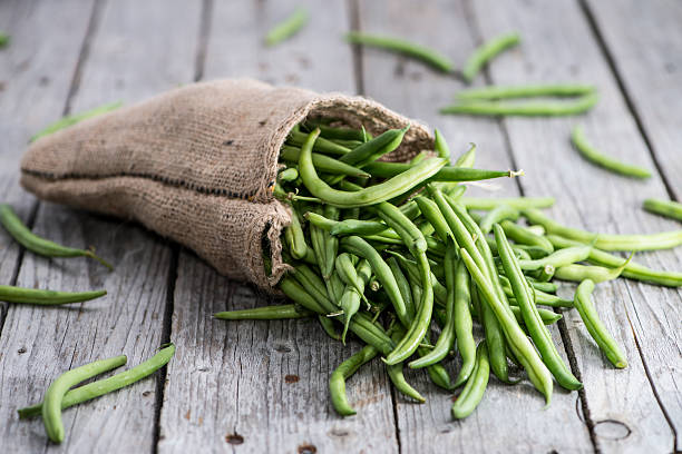 Some Green Beans on wood Some Green Beans on wooden background green bean stock pictures, royalty-free photos & images