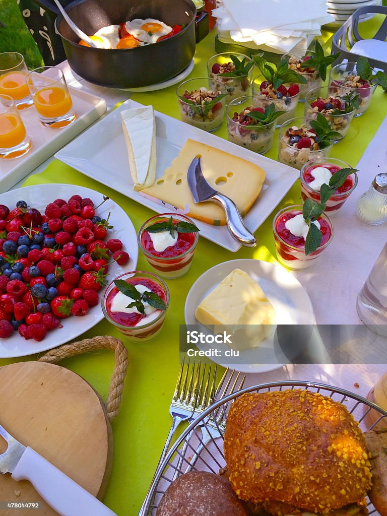 Brunch table with buns, berries, butter, cheese, müsli, eggs etc. 2015 Stock Photo