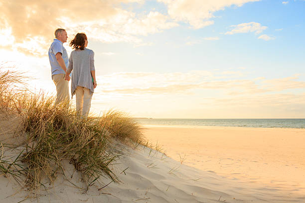 pareja madura en la playa - couple mature adult action walking fotografías e imágenes de stock