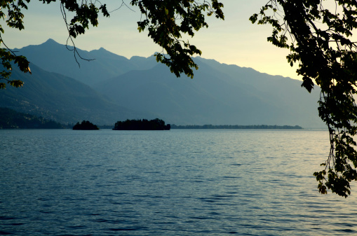 Sunshine over an alpine lake with brissago islands and mountain in ticino switzerland