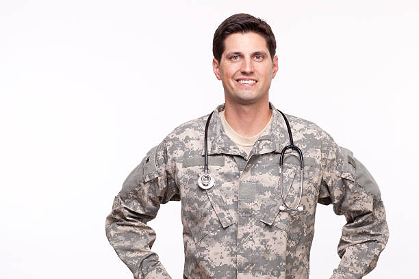 Portrait of a young military doctor posing against white backgro stock photo