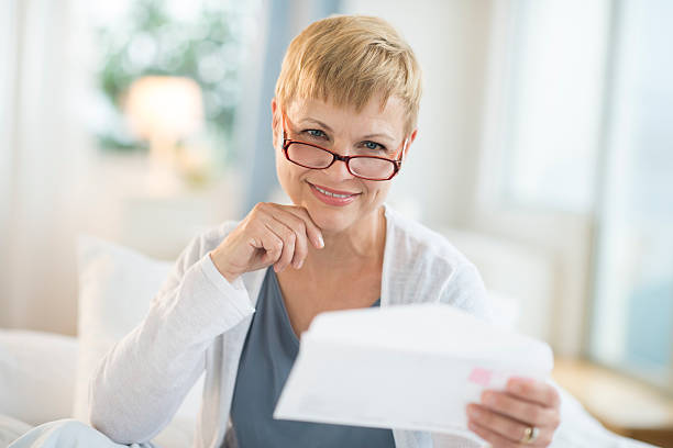 istock Smiling Mature Woman Holding Envelope 478052011