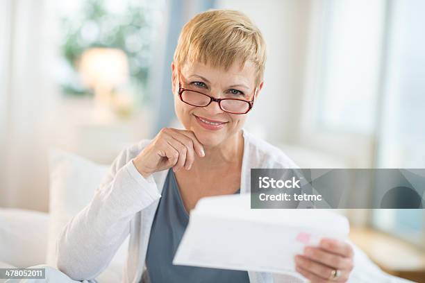 Smiling Mature Woman Holding Envelope Stock Photo - Download Image Now - Envelope, Holding, Women