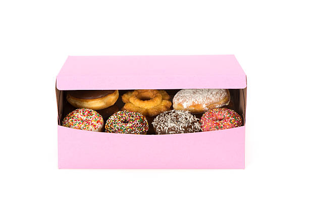 istock Decorated doughnuts in a partially opened pink box-isolated on white 478053045
