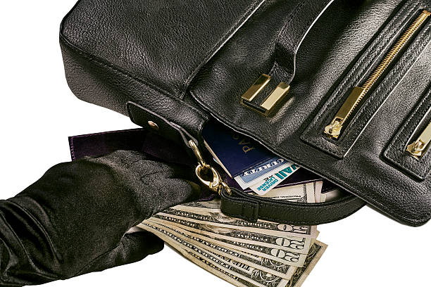 Stolen Identity Image of a gloved hand reacing for money and a wallet revealing a passport, social security card and driver license with a black purse isolated on white social security social security card identity us currency stock pictures, royalty-free photos & images