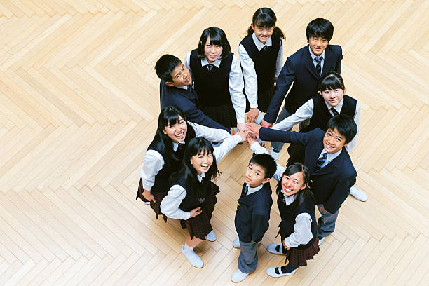 Overhead view of high school students joining hands Overhead view of a Group of Japanese high school students joining hands high school student child little boys junior high stock pictures, royalty-free photos & images