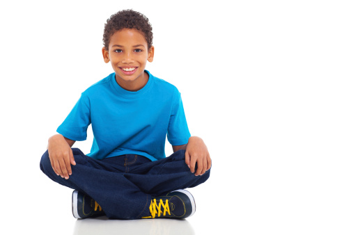 cute african american boy sitting on white background