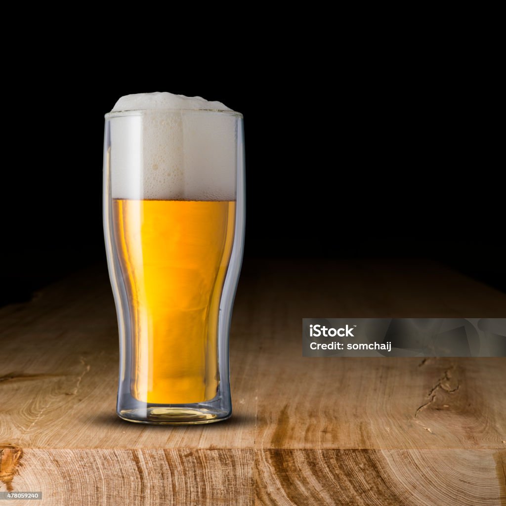 Glass of cold beer Glass of cold beer on wood table 2015 Stock Photo