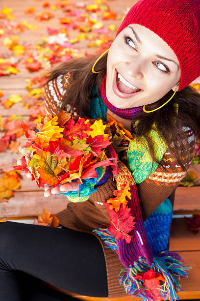 istock Smiling woman holding autumn leaves 478060285