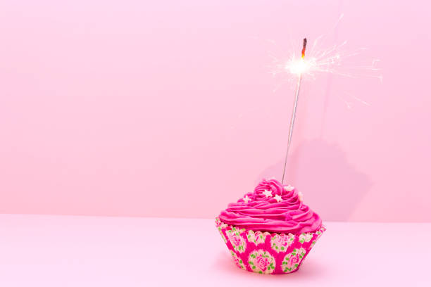 istock Pink birthday cupcake with sparkler 478061340