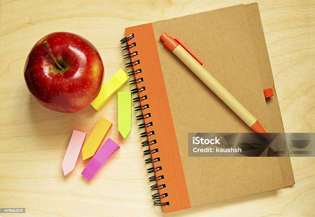 Notebook, pen,  stickers and apple Notebook, pen,  stickers and apple on wooden desk Apple - Fruit Stock Photo