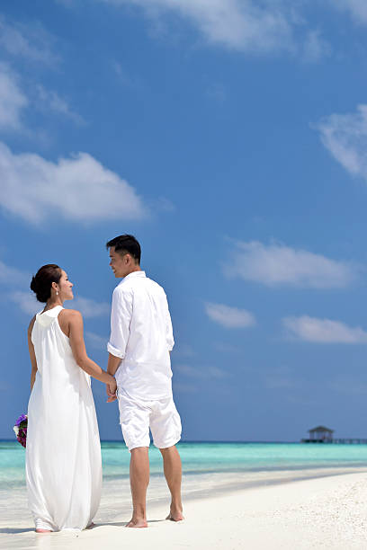 Happy chinese asian couple in maldives wedding shoot stock photo