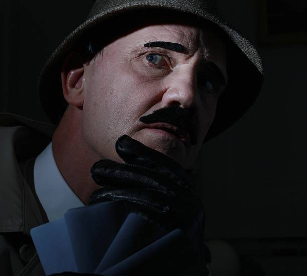 istock mature man dressed as detective playing cards 478066914