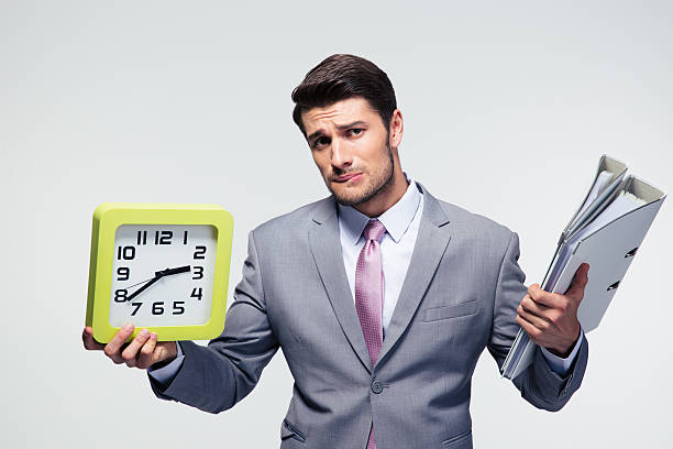 istock Unhappy businessman holding folders and clock 478067214