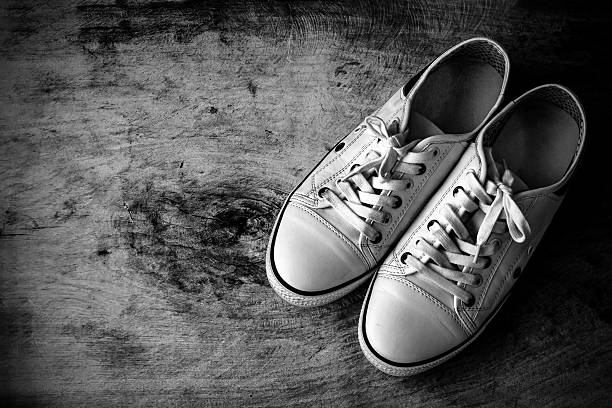 istock White canvas shoes on old wooden floor 478069822