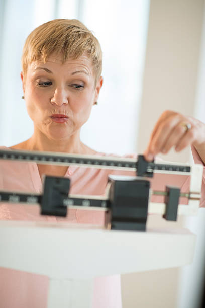 istock Mature Woman Adjusting Sliding Weight Scale 478075767