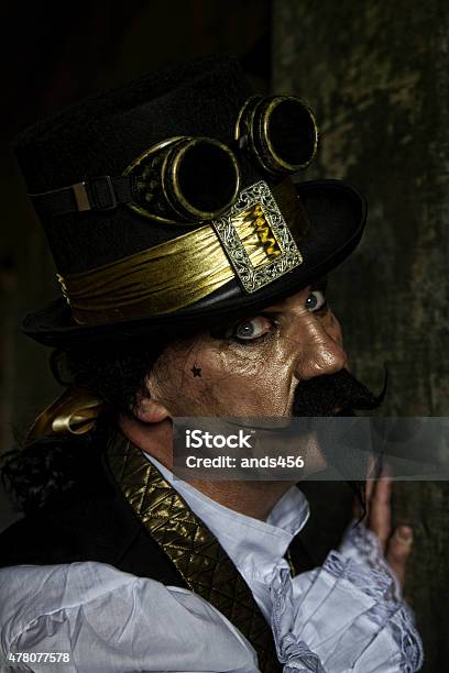 Man Dressed In Steampunk Victorian Clothing Dark Wall Background Stock Photo - Download Image Now