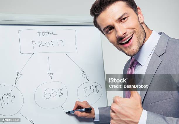 Happy Businessman Writing On A Flipchart Stock Photo - Download Image Now - 2015, Adult, Beautiful People