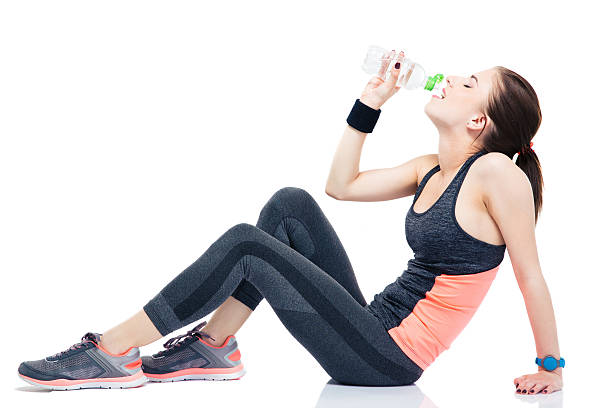 istock Woman sitting on the floor and drinking water 478083258