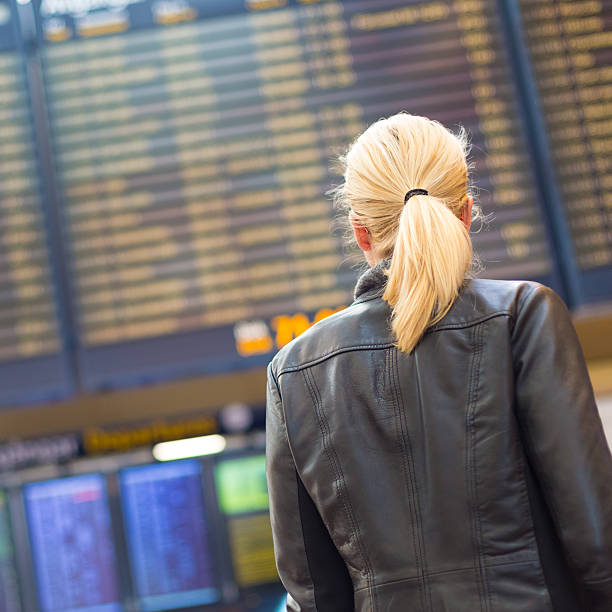 istock Female traveller checking flight departures board. 478083430
