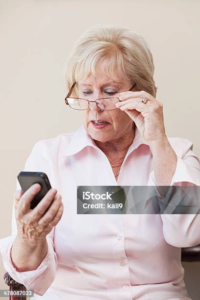 Senior Donna Guardando Il Cellulare - Fotografie stock e altre immagini di Contrariato - Contrariato, Donne mature, Mandare un SMS