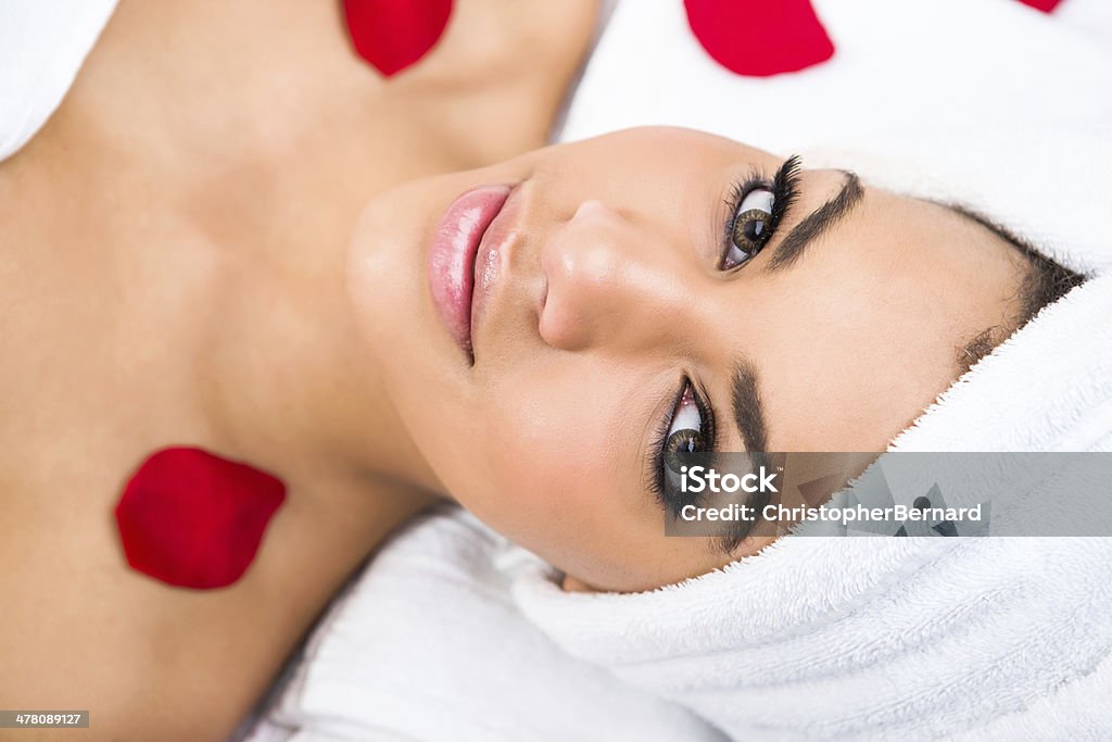 Mulher sorridente no spa com pétalas de rosas - Foto de stock de 18-19 Anos royalty-free