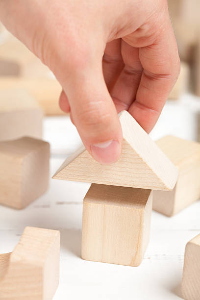 istock Wooden toy house with hand on white table 478096208