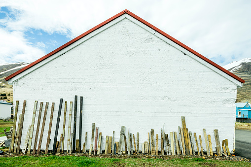 Recycled timber drying against a building, Iceland, North-Eastern Iceland