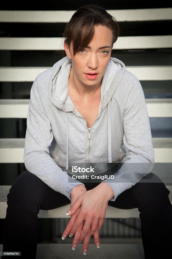 Female Athlete Waits A female athlete wearing her sports training clothes. She is sitting on the stairs looking at camera. 20-29 Years Stock Photo