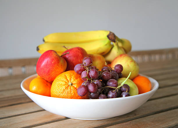 bowl of fresh fruit a bowl of fresh fruit set on a wooden table fruit bowl stock pictures, royalty-free photos & images