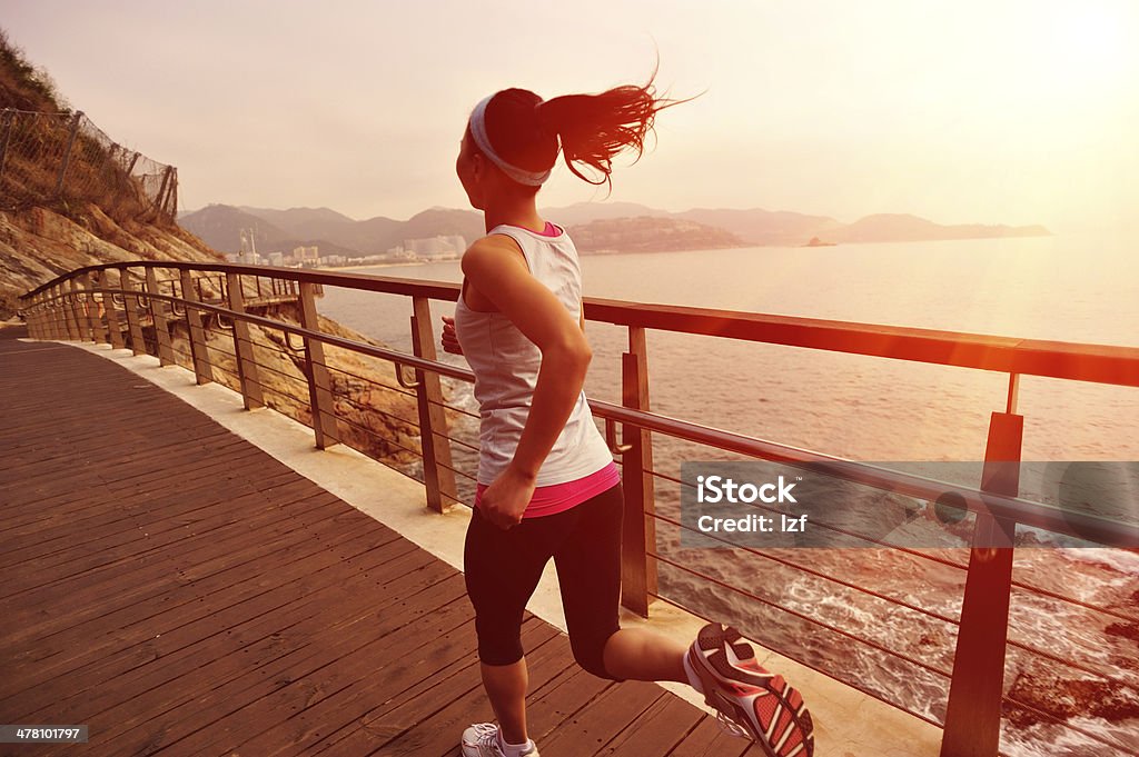 healthy lifestyle asian woman running at wooden trail seaside Active Lifestyle Stock Photo