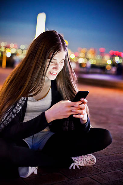 istock Smiling young woman texting with smart phone at night, Tokyo 478106700