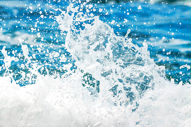 Beautiful water background with splashing ocean water over the rocks with bubbles and waves, full frame horizontal composition with copy space