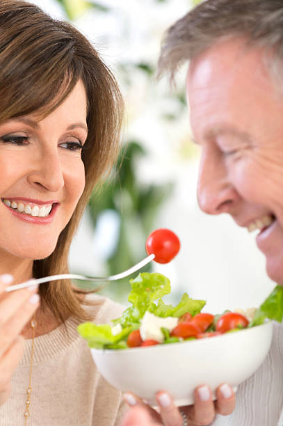 istock Mature woman feeding man salad 478106961