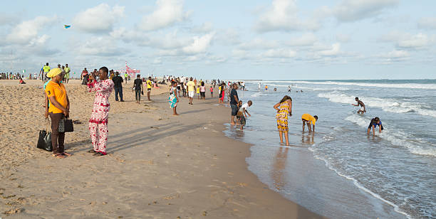 Lomé, Togo - June 30, 2019: Young women enjoy the beach of Lomé at the late afternoon.