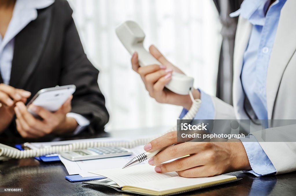 Writing and telephone Businesswoman writing down while receiving telephone Note Pad Stock Photo