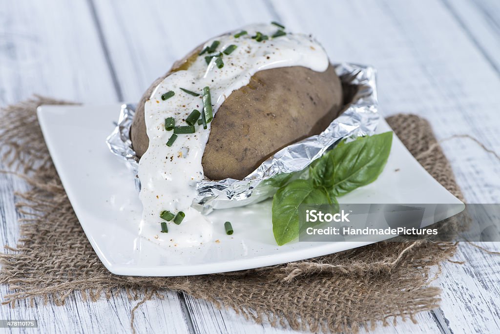 Fresh Baked Potatoe Fresh Baked Potatoe with Cream and Herbs on vintage wooden background Aluminum Stock Photo