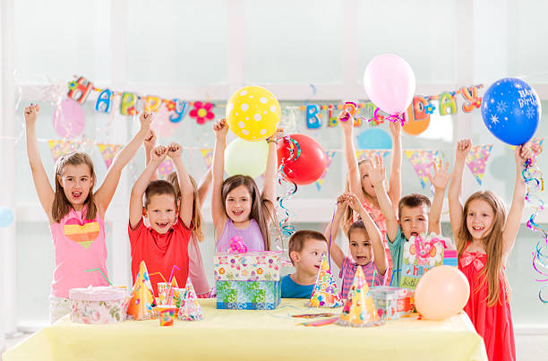 istock Cheerful children with raised hands celebrating birthday. 478110508