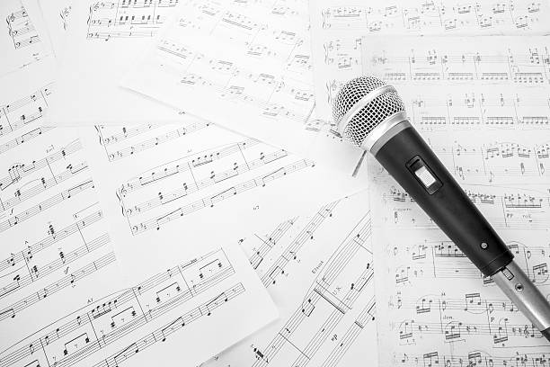 dynamic microphone on music sheet dynamic microphone on music sheet B&W film processed school choir stock pictures, royalty-free photos & images