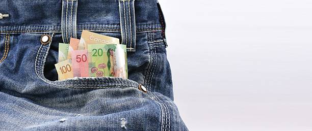 dollari canadesi soldi in tasca di jeans in denim blu - canadian dollars canada bill one hundred dollar bill foto e immagini stock