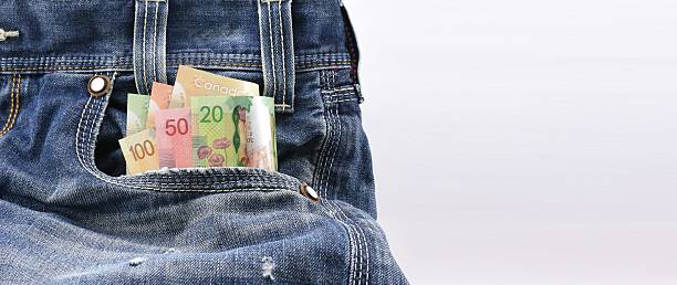 Canadian dollars money in blue denim jeans pocket Canadian dollars of value 20, 50 and 100 in Blue Denim Jeans Pocket, Concept on earning money, saving money, sales with ample empty space for text message on the picture singh stock pictures, royalty-free photos & images