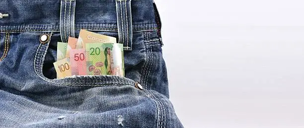 Photo of Canadian dollars money in blue denim jeans pocket