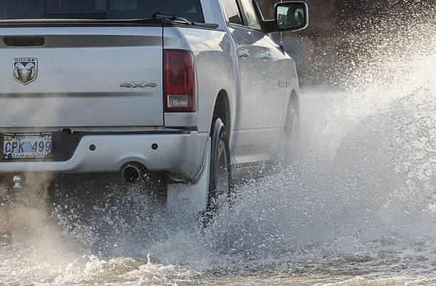 Driving in Flood Waters Hammonds Plains, Canada - December 11, 2014: A pickup truck navigates flood waters covering the Hammonds Plains Road after a heavy rainfall. truck rain stock pictures, royalty-free photos & images